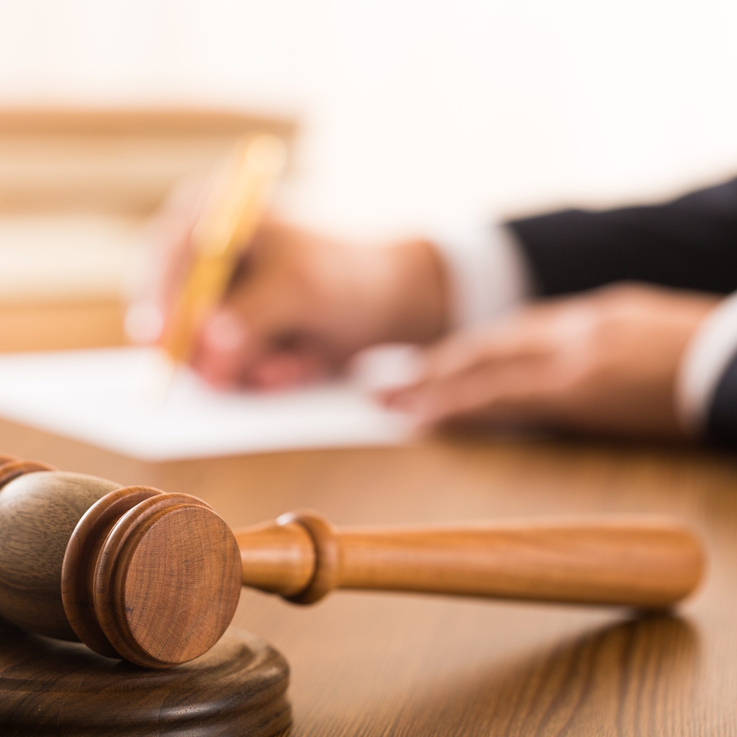 Closeup of Gavel with Lawyer Writing on Background