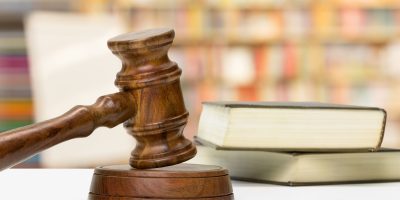 Wooden gavel and books on wooden table
